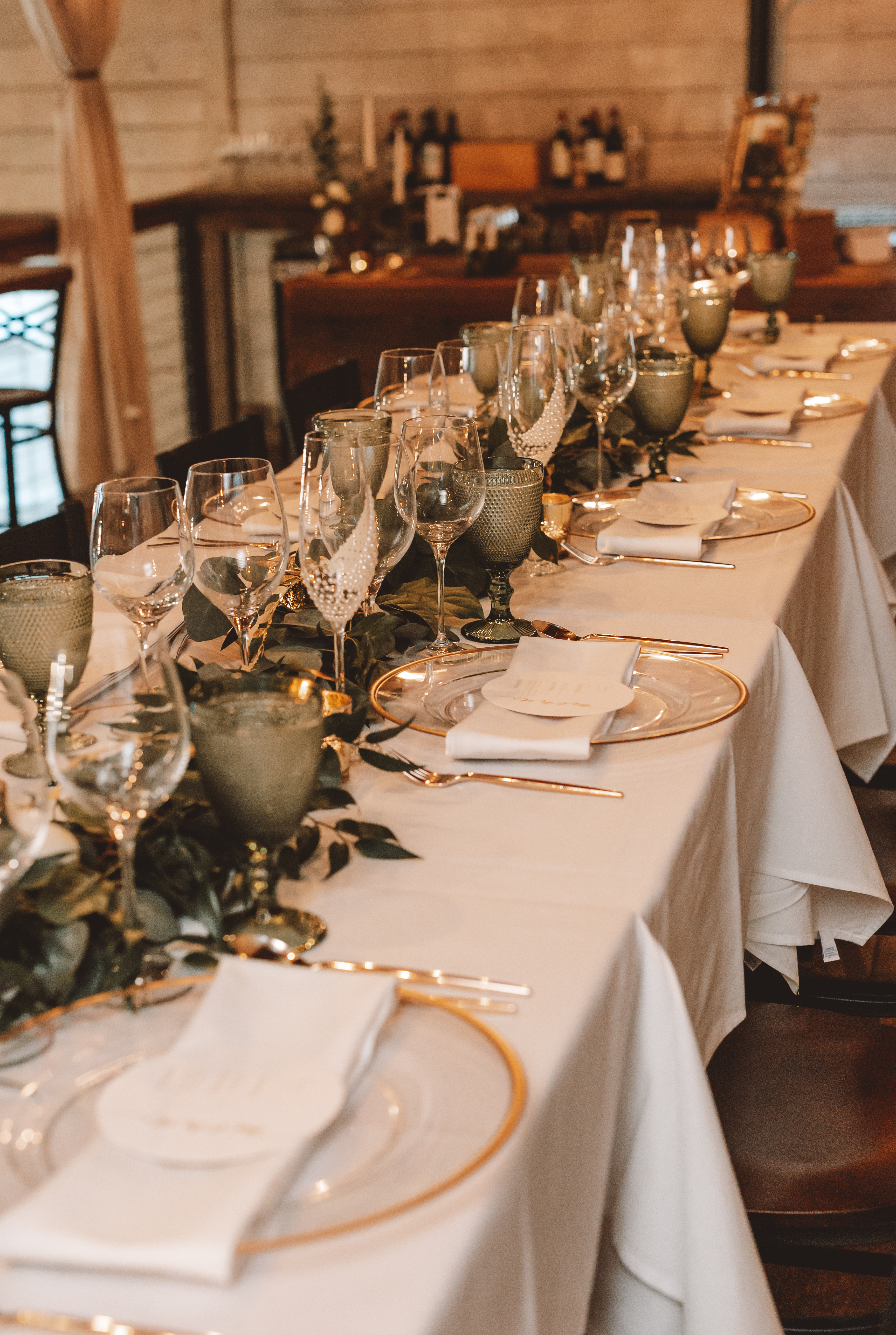 Image of a Table set with a white tablecloth and gilded plates.